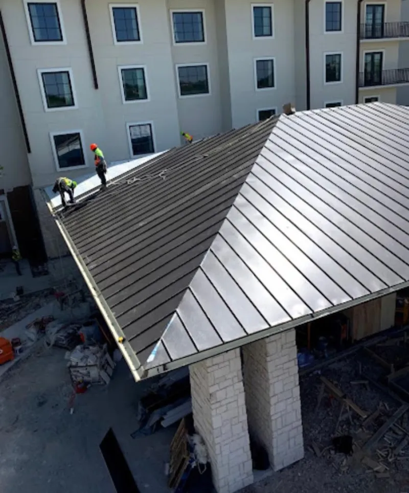 Crew installing standing seam metal roof panels on a commercial project in Ferndale